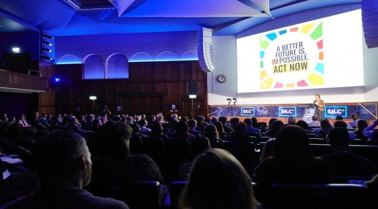 The United Nations' Caroline Petit stands on stage at the Royal Geographical Society in London delivering the conference's keynote speech
