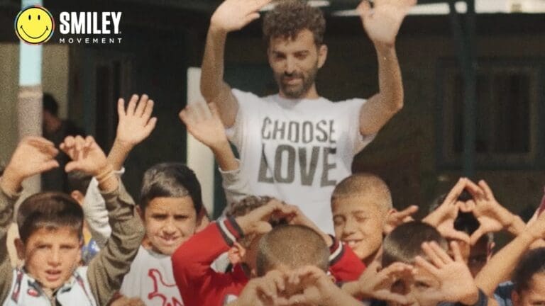 A crowd of people waving and forming hearts with their hands