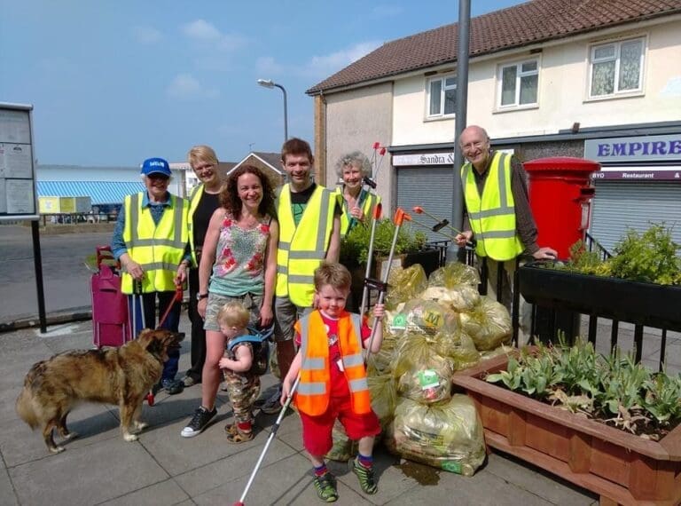 A group of people holding litter pickers and bin bags.