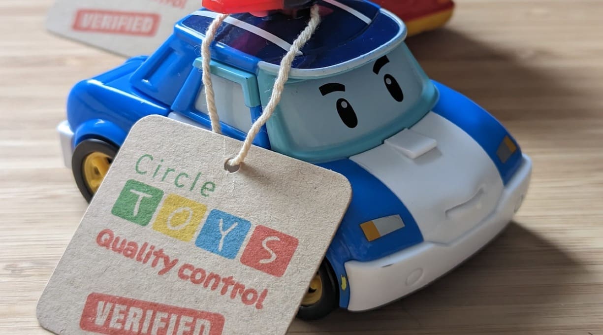 a blue and white toy car with a Circle Toys label attached
